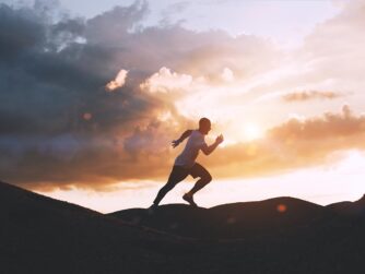 Athlete runs quickly through the hills outdoors at sunset. healthy lifestyle concept